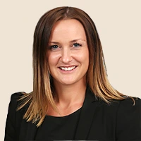 Smiling professional woman pointing at a wristwatch. Time management tips.