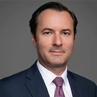 Professional headshot of a man in a suit and tie.