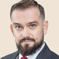 Headshot of a man with a beard wearing a suit