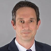 Professional headshot of a man wearing a suit and tie.