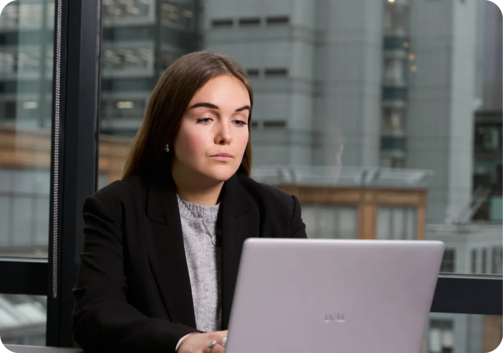 Woman working on a Dell laptop in a modern office, focusing on productivity.