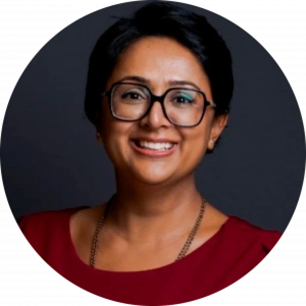 Professional woman smiling, wearing glasses. Financial services rebrand.