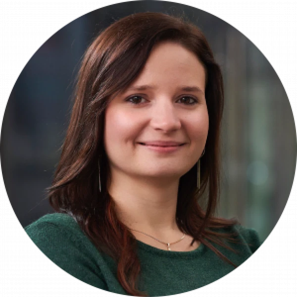 Portrait of a smiling woman in a green sweater. Financial services rebrand leader.