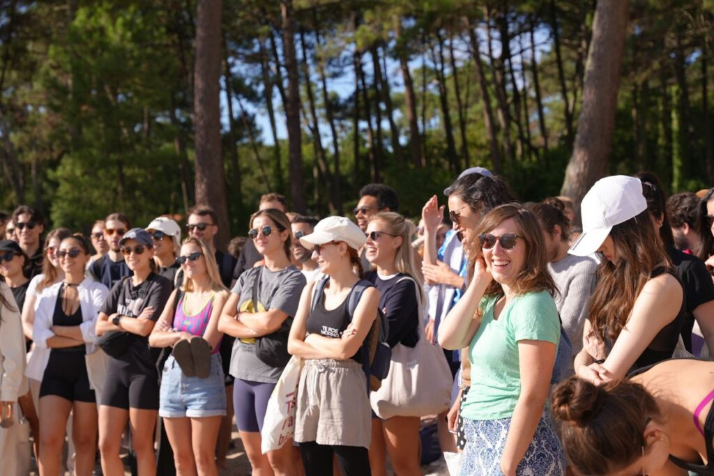 Upside B Corp event attendees in a forest clearing, smiling and engaged.